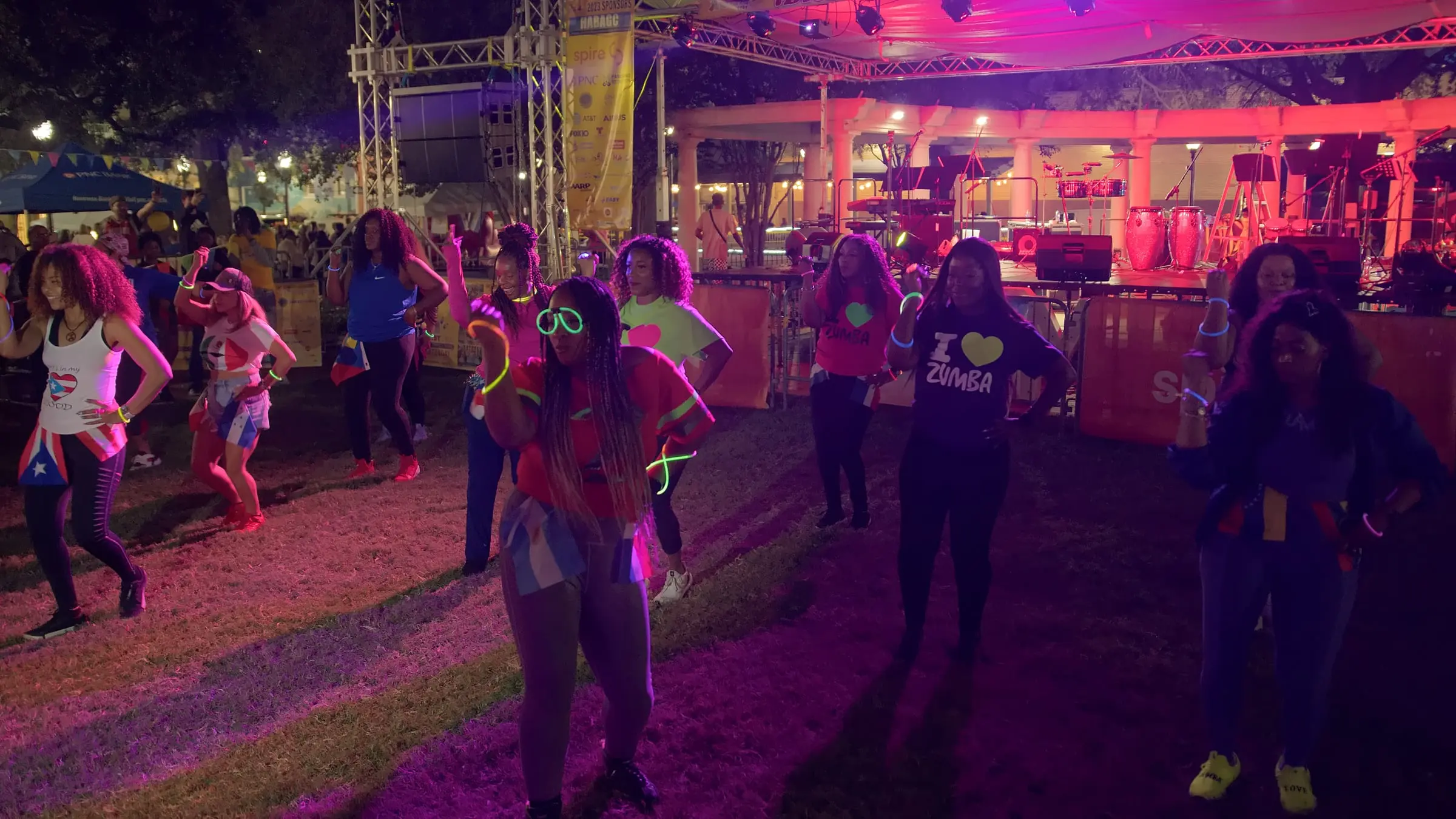 Festival-goers dance under pink stage lights at night, photographed by AVO Dynamics at Mobile Latin Fest 2023